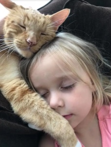 Cat sleeping with her human sister